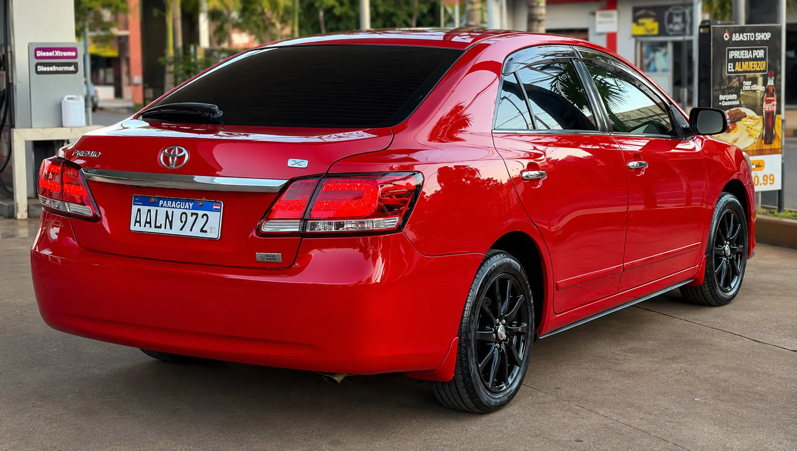 Toyota Premio roja, vista trasera con sus insignias y llantas negras